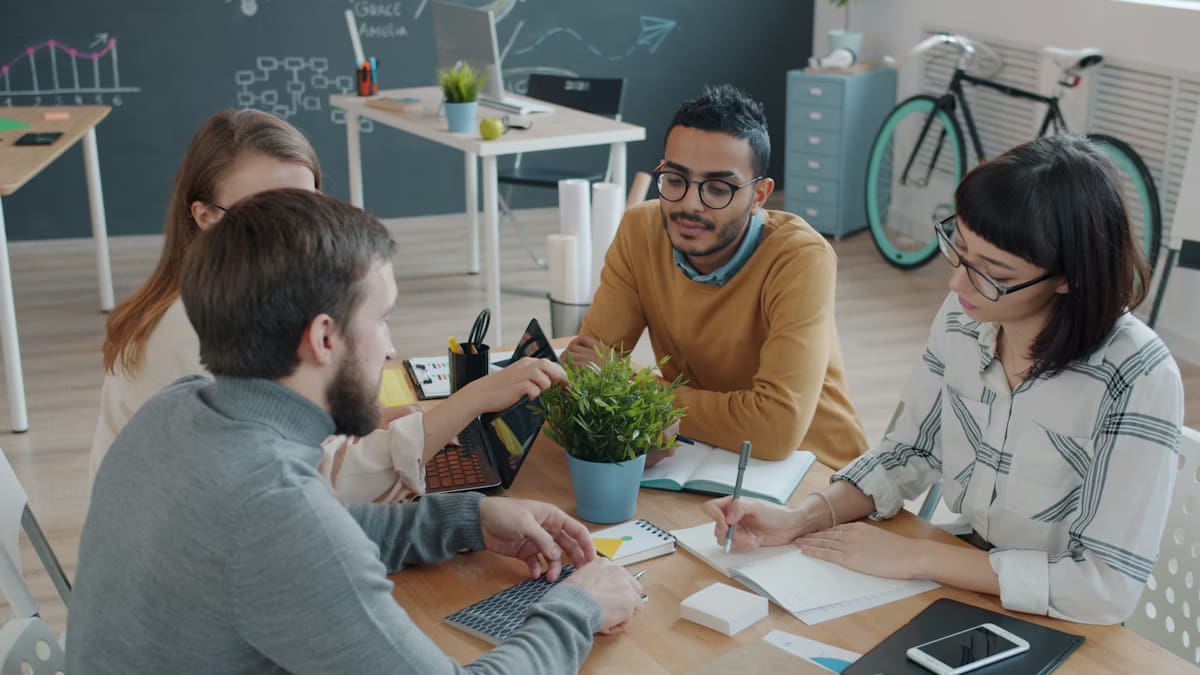A team collaborating around a laptop in a bright office
